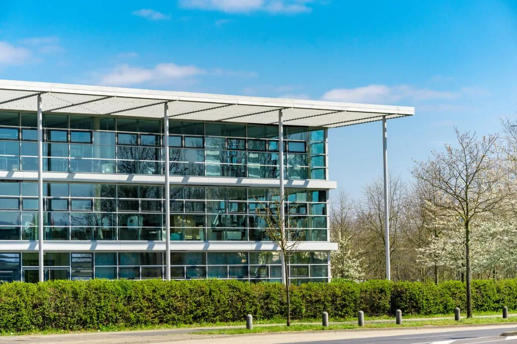 glass-office-building-green-city-2023-11-27-04-52-26-utc