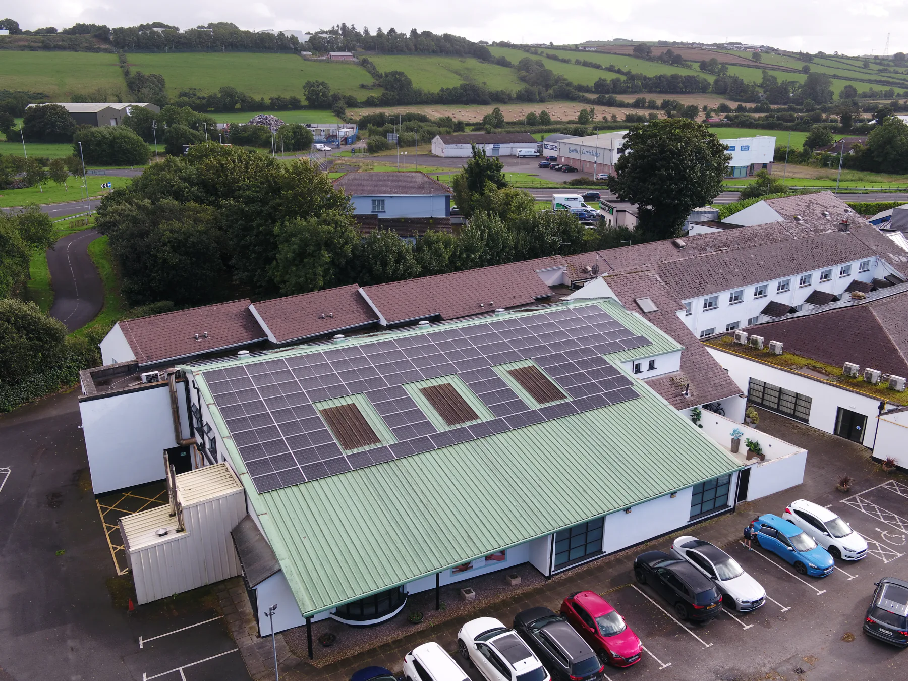 Wide aerial view of the White Horse Hotel solar installation with countryside beyond